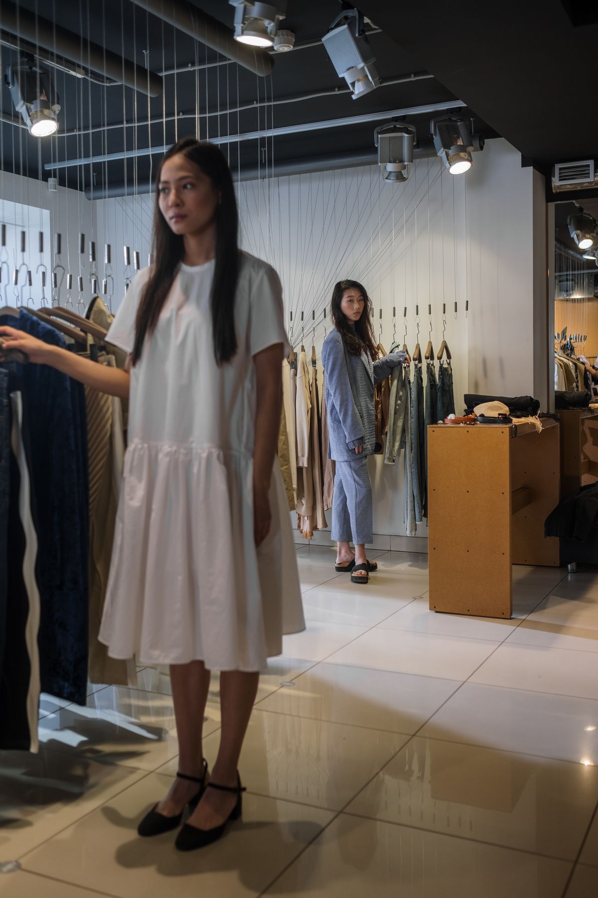 A calm womenswear shop floor with garments on display