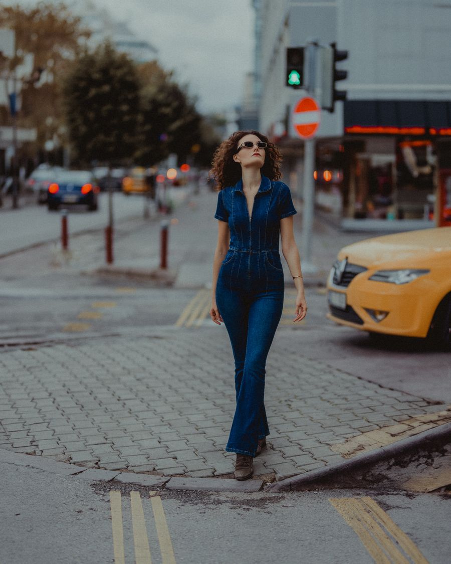 A woman in denim walking down a city street